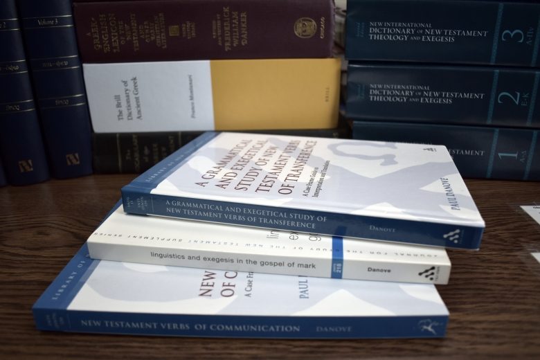 books on a table, with the spines of these showing: A Grammatical and Exegetical Study of New Testament Verbs of Transference, Linguistics and Exegesis in the Gospel of Mark, and New Testament Verbs of Communication