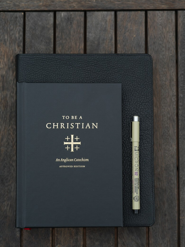 To Be a Christian cover on top of notebook on tabletop